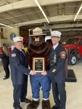 Deputy Fire Commissioner Rick Poplaski, left, and Frank Loporto, chief of West Milford Fire Company 2, pose with the award and Smokey the Bear. (Photo provided)