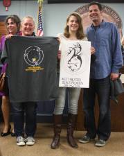 Ashley Santangelo is flanked by her proud parents, holding her artwork and the t-shirt, which all volunteers will receive at Beautification Day.