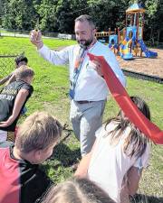 Marshall Hill Elementary School principal Patrick O’Donnell cuts the ribbon on the school’s new playground.