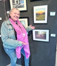 Sarah Loukos stands with her piece, Last Day's Glow.