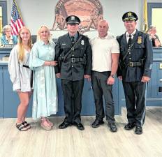 New West Milford police officer Mateusz Kaldon poses with family after being sworn in.