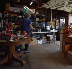 Sue Lynch, chairwoman of the Friends of the Wallisch Homestead, finds a box for a customer at the barn sale. (Photos by Fred Ashplant)