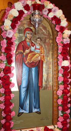 The icon of Santa Maria in the chapel is bedecked by flowers for the day of honoring the mother of Jesus.
