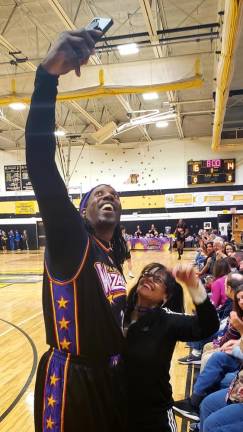 Big J of the Harlem Wizards takes a selfie with Maria Mealay.