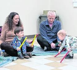 Children discover the beat as the adults look on.