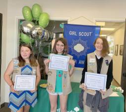 Girl Scouts Zoe Lisbona, Emma Morgan and Gretchen Ileczko hold up their hard earned Silver Award certificates.