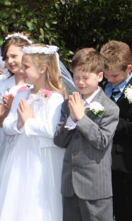 Is this young man, Max Phalon, deep in prayer or is it the sun in his eyes? Phalon was among the eleven children who received their First Holy Communion at Queen of Peace Church in West Milford on 4/28/12. Pictured here also, left to right, is Victoria Evanchick, Lauren Marci and Seamus McGuiness. Photo by Ginny Raue