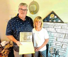 Dave Smith and Kendall Kless at their home in Warwick, N.Y. He holds a photo of his father, Steve, a Vietnam War veteran who died in December. (Photo by Rich Adamonis)