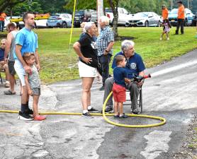 A boy takes a turn pointing the fire hose during the National Night Out event Tuesday, Aug. 5 at West Milford High School. (Photos by Fred Ashplant)