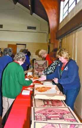 Patti Gillis of West Milford Community Services and Recreation, right, serves up the pizza slices after the musical performance.