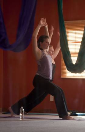 Alison Carbone and Alice Olszewski take part in a yoga class with "hands to heart."