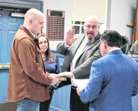Senator Anthony Bucco (LD-25) swears in Councilman Kevin Goodsir to his third term on the West Milford Township Council as his wife and son look on.