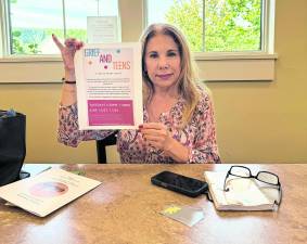 Maria Ojeda Pasterchick holds up a paper titled, Grief and Teens.
