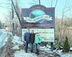 Don Smith, Dennis Decina and Susan Bemel stand in front of the sign.