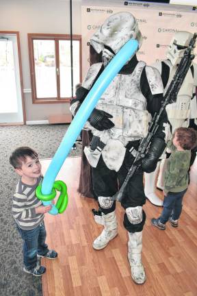 A young boy looks ready to take on a Star Wars Storm Trooper.