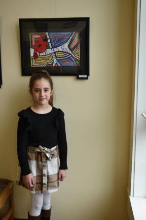 Myla Finamore, 9, stands before her painting on display at the library.