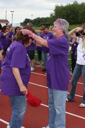 Cancer survivor and communications director for the Relay, Joan Hopper, on right, places medalion on fellow survivor. Photo by Ginny Raue