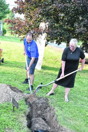 West Milford Community Services and Recreation Department Director Daniel Kochakji, left, and Mayor Michele Dale shovel soil atop the time capsule.