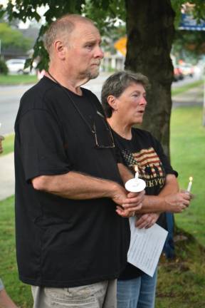 Residents hold candles during the ceremony Monday, Sept. 11.