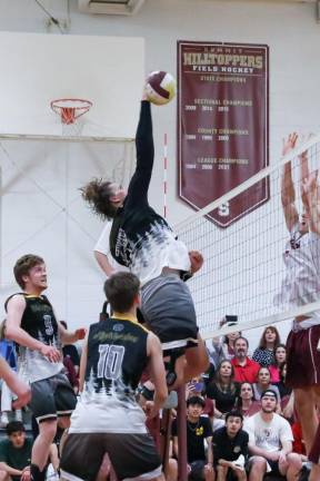 Andre Christ compresses the ball on a spike into Summit’s front row.
