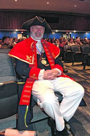 Denville's official Town Crier Douglas Gabel poses dressed in a red and gold coat, white breeches, black boots and a tricorne hat as was the tradition dating back to the 18th century.