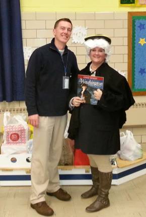 Hillview Principal Michael Portas and Media Specialist Valerie Munro stand in front of the generous donations of the Pequannock/Pompton Plains residents