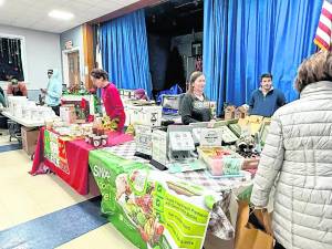 A customer peruses the tables at the West Milford Farmer’s Market.