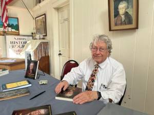 Hans Niederstrasser signs books at the Long Pond Ironworks Historic District in November. (Photo by Ann Genader)