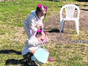 Joellen Matrille, 4, of West Milford and her sister Eleanor, 2, pick up Easter eggs Sunday, March 24 outside American Legion Post 289 in West Milford. (Photo by Kathy Shwiff)