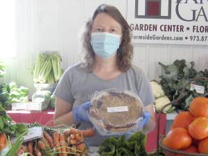 Market organizer Donna Traylor displays one of the delicious pies at the Sussex County Fairground Farmers Market last summer (Photo by Janet Redyke)