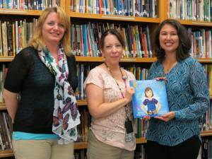 Photos by Patricia Keller Cheryl Crouthamel, left, illustrator for the Mommy Fix It Up book, and author Mary L. Moore, right, present a copy of the book to Julianne McCall-Bramley, media specialist at Apshawa Elementary School.