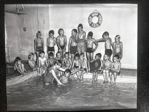 Boys watch and wait their turn while a classmate gets a swim lesson at a pool in the basement of the Idylease building. (File photos by Ann Genader)