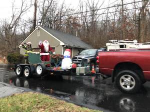 Santa and his assistant are pulled through the Hewitt section of West Milford by members of Fire Company 3 on Sunday, Dec. 17. The township’s six volunteer fire companies tried to bring the jolly old elf to all streets in West Milford. (Photo by Kathy Shwiff)