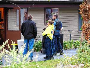 FR1 A first-responder holds a cat outside a house on Cliff Road where a fire was reported Sept. 23. (Photo by Frank S. Cheh)