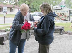 Bev Lujbli (left), retiring after 50 years as a West Milford First Aid Squad volunteer, knows first hand about the 9/11 attack in New York City. She was one of the local squad members who volunteered with assistance at Ground Zero after the attack. In this photo, she prepares with a colleague to place memorial roses at the 9/11 Memorial Park in front of the West Milford Municipal Building. Photo by Ann Genader.