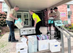 Members of the First Aid Squad pack up donated school supplies.