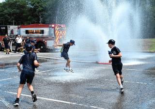 West Milford Junior Police Academy cadets cool off in spray from a new specialized spraying device used by township firefighters. (Photos by Rich Adamonis)