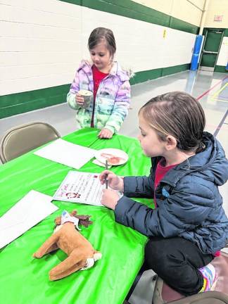 Emma, 5, and Anna Cerone, 6, of West Milford, write letters to Santa Claus and drink hot chocolate.