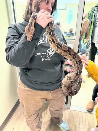 Erin Mellini of Snakes-N-Scales shows lets a child feel a snake.