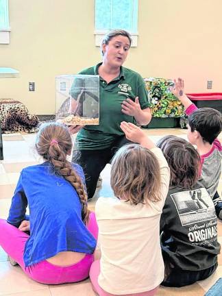 Devon Santoro shows an animal to children.