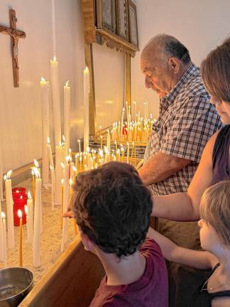 Church-goers light candles inside Holy Institution Panagia Soumela, which promotes and preserves Pontic-Hellenic history, culture and civilization.