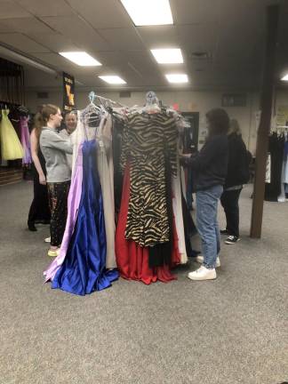 Shoppers look through the donated formal and semiformal dresses at West Milford High School.