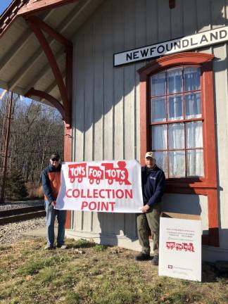 Matt Klemchalk, left, manager of the Newfoundland Train Station, and John Sobotka, a train coordinator with Operation Toy Train, advertise the new stop on the collection train. (Photo by Kathy Shwiff)