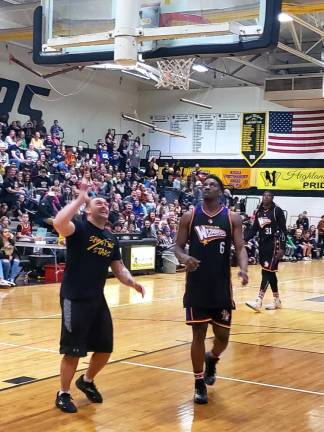 A West Milford teacher makes a point to a member of the Harlem Wizards team.