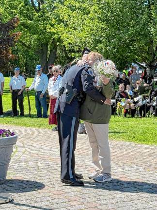 Shirley Parrello, whose son Brian was killed in Iraq in 2005, receives flowers and a hug during the Memorial Day ceremony at Veterans Memorial Park. (Photo by Denise von Wilke)