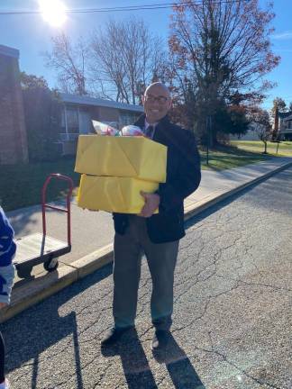 KC2 Jared Fowler, principal of Upper Greenwood Lake Elementary School, carries boxes of donations.
