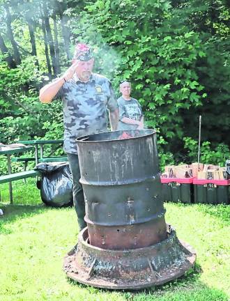 West Milford VFW Commander Rudy Hass salutes a retired American flag.