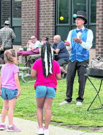 A juggler performs for children.
