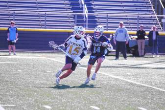 <b>Vernon's Andrew Geisen carries the ball with his crosse while covered by Sparta's Danny Westervelt in their game April 17. The Spartans won, 15-0. (Photos by</b> <b>George Leroy Hunter)</b>