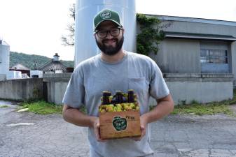 Head cider maker Cooper Graney with a six pack of Doc’s pear cider.